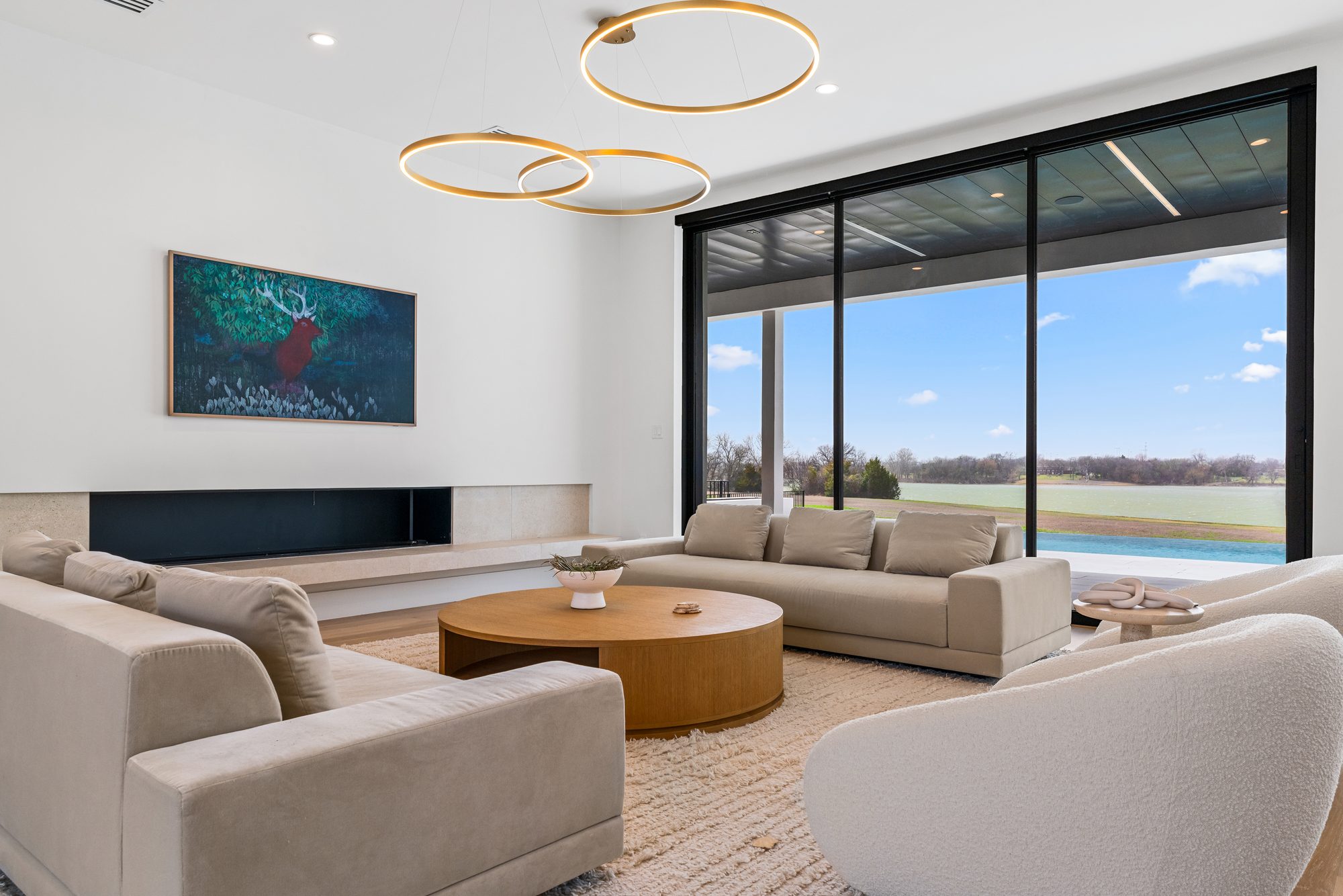 Long linear fireplace with a stone hearth, and the lake through the glass beyond
